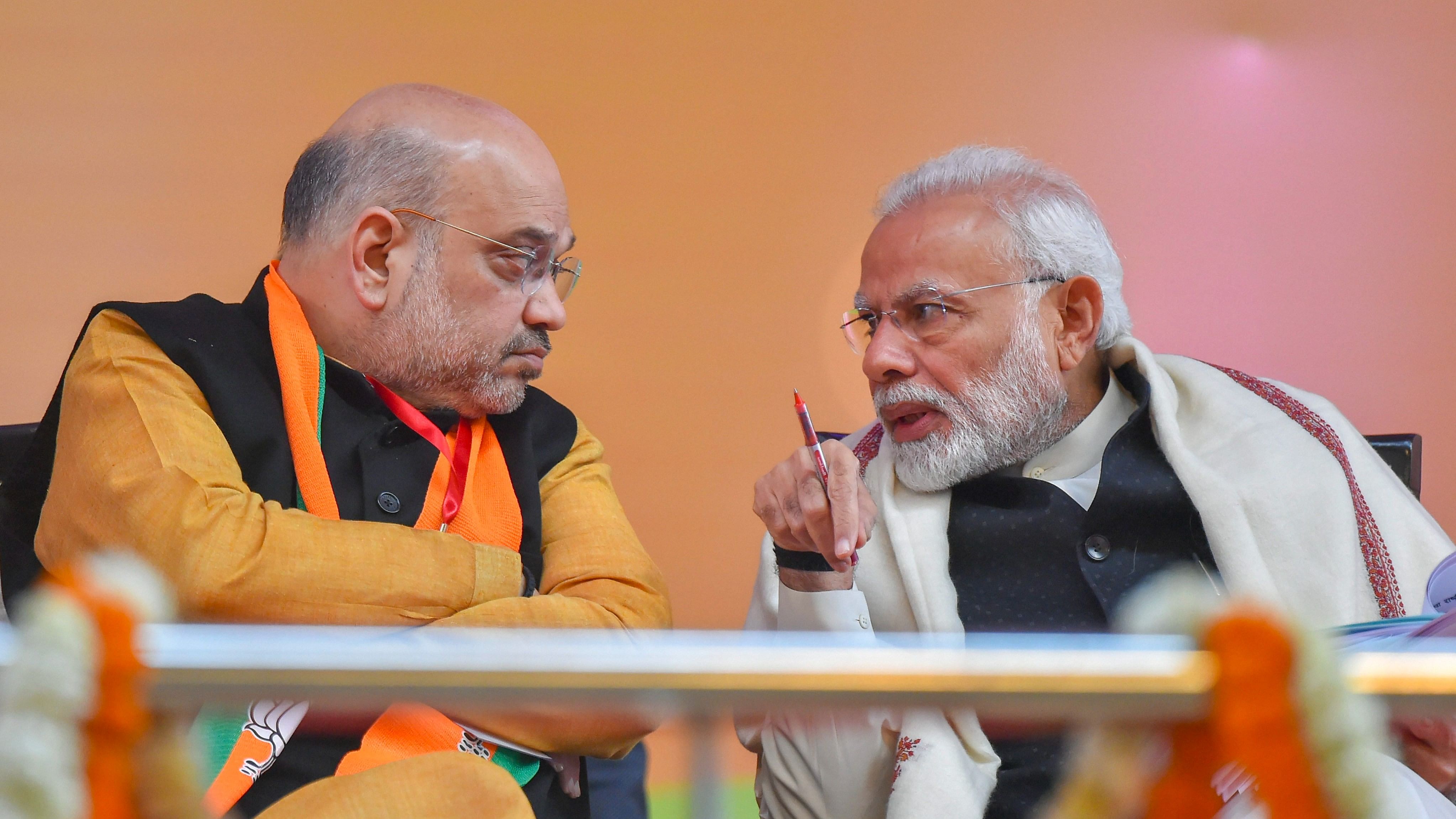 <div class="paragraphs"><p>Prime Minister Narendra Modi speaks with  Amit Shah.</p></div>