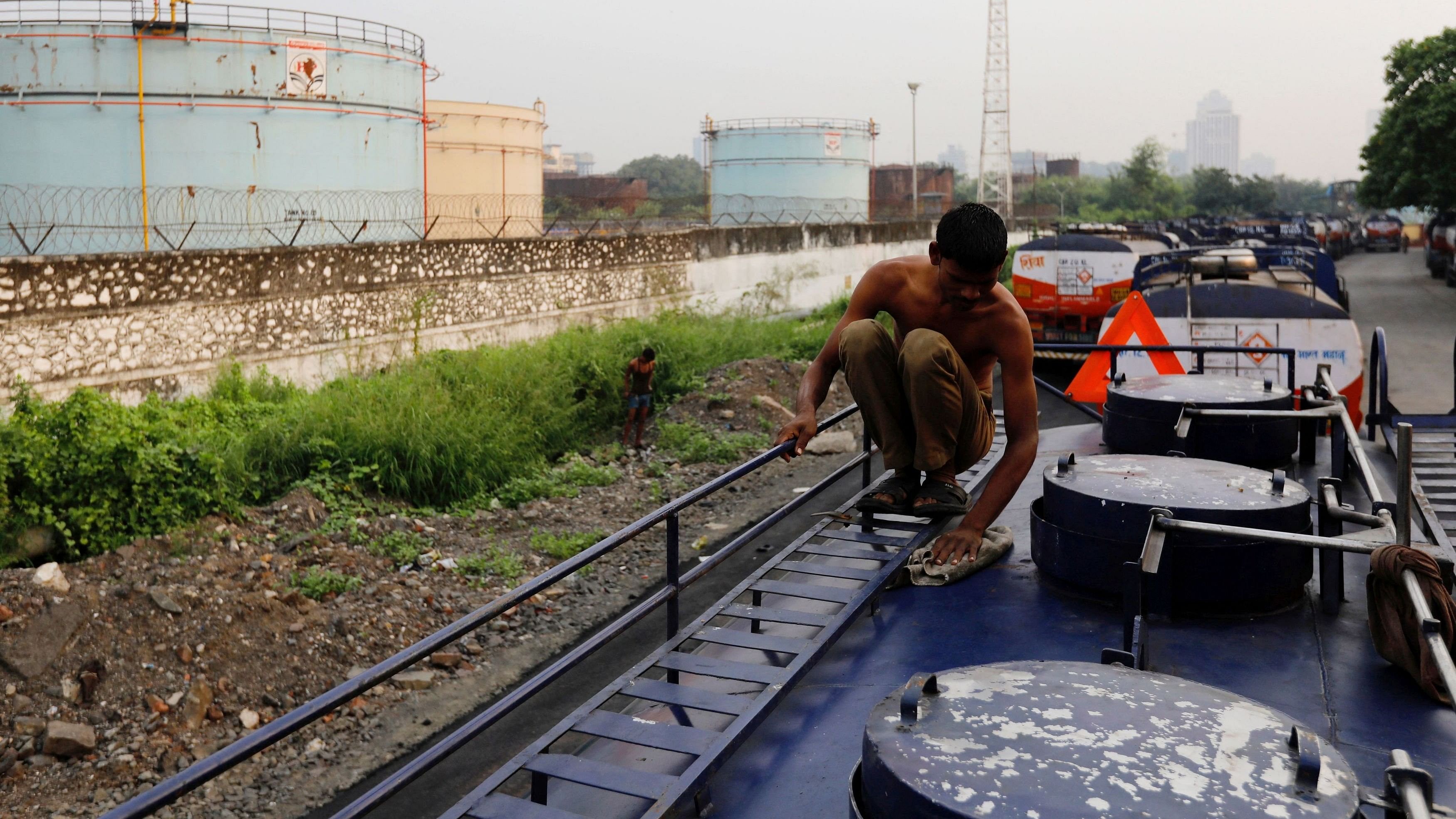 <div class="paragraphs"><p>A man cleans an oil tanker parked outside a Hindustan Petroleum fuel depot in Mumbai, India</p></div>