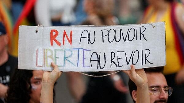 <div class="paragraphs"><p>An attendee holds a placard that reads "The RN to the power, goodbye to freedom", against the French far-right Rassemblement National (National Rally - RN) party during the Marche des Fiertes LGBTQI+ (Paris annual Pride parade) in Paris, on the eve of the first round of the early French parliamentary elections in France, June 29, 2024.</p></div>
