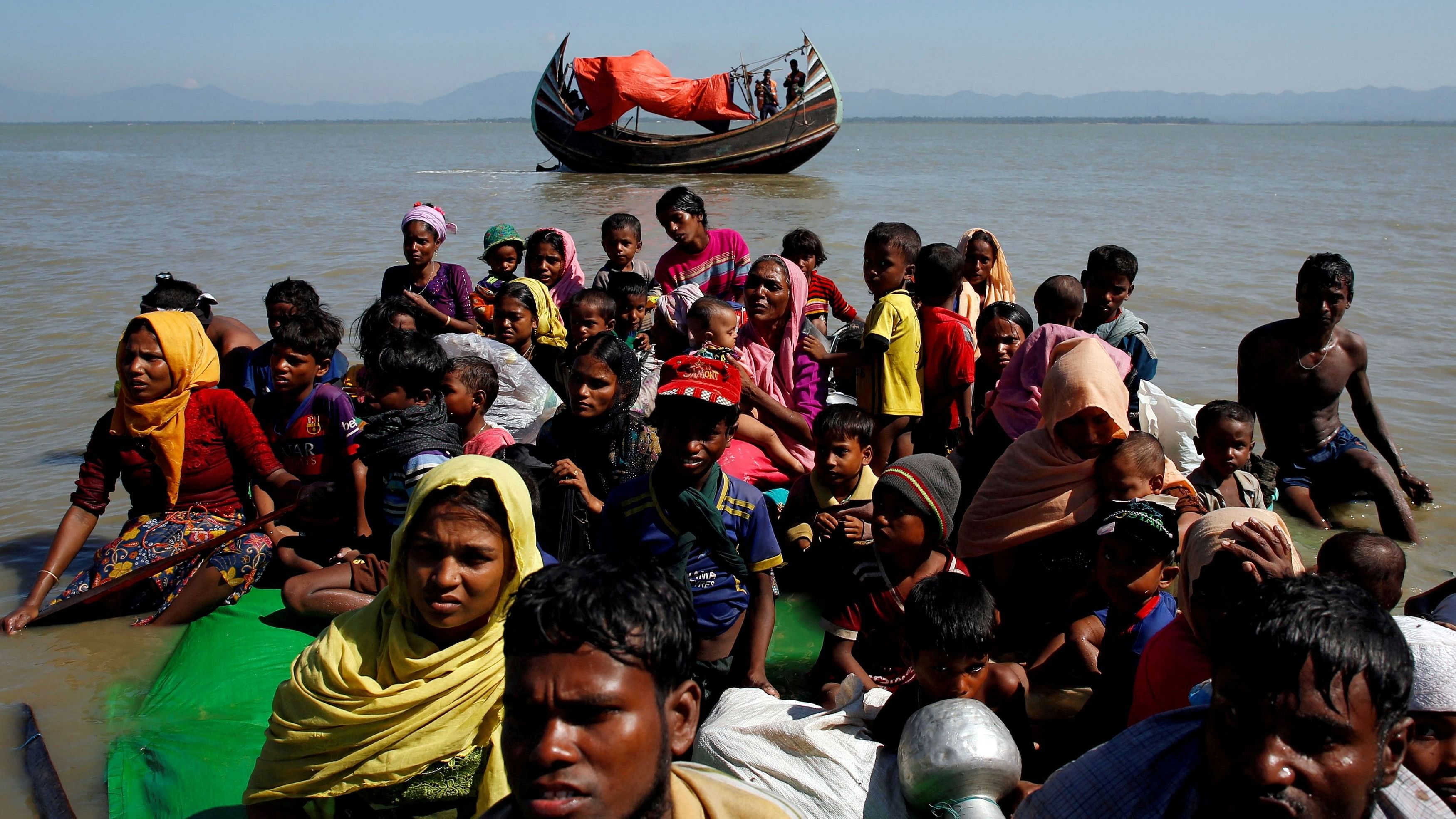 <div class="paragraphs"><p>Rohingya refugees sit on a makeshift boat.</p></div>