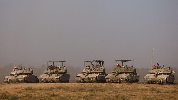 <div class="paragraphs"><p>Israeli soldiers work on their tanks near the Israel-Gaza border, amid the Israel-Hamas conflict, in Israel.</p></div>