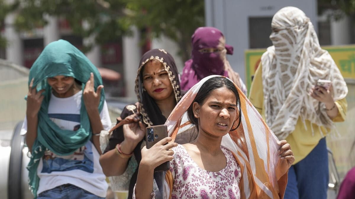 <div class="paragraphs"><p>Women cover their heads for protection from the scorching sun on a hot summer day, in New Delhi, Tuesday, June 18, 2024. The India Meteorological Department (IMD) has issued a 'red' alert because of prevailing heatwave conditions in the national capital. </p></div>