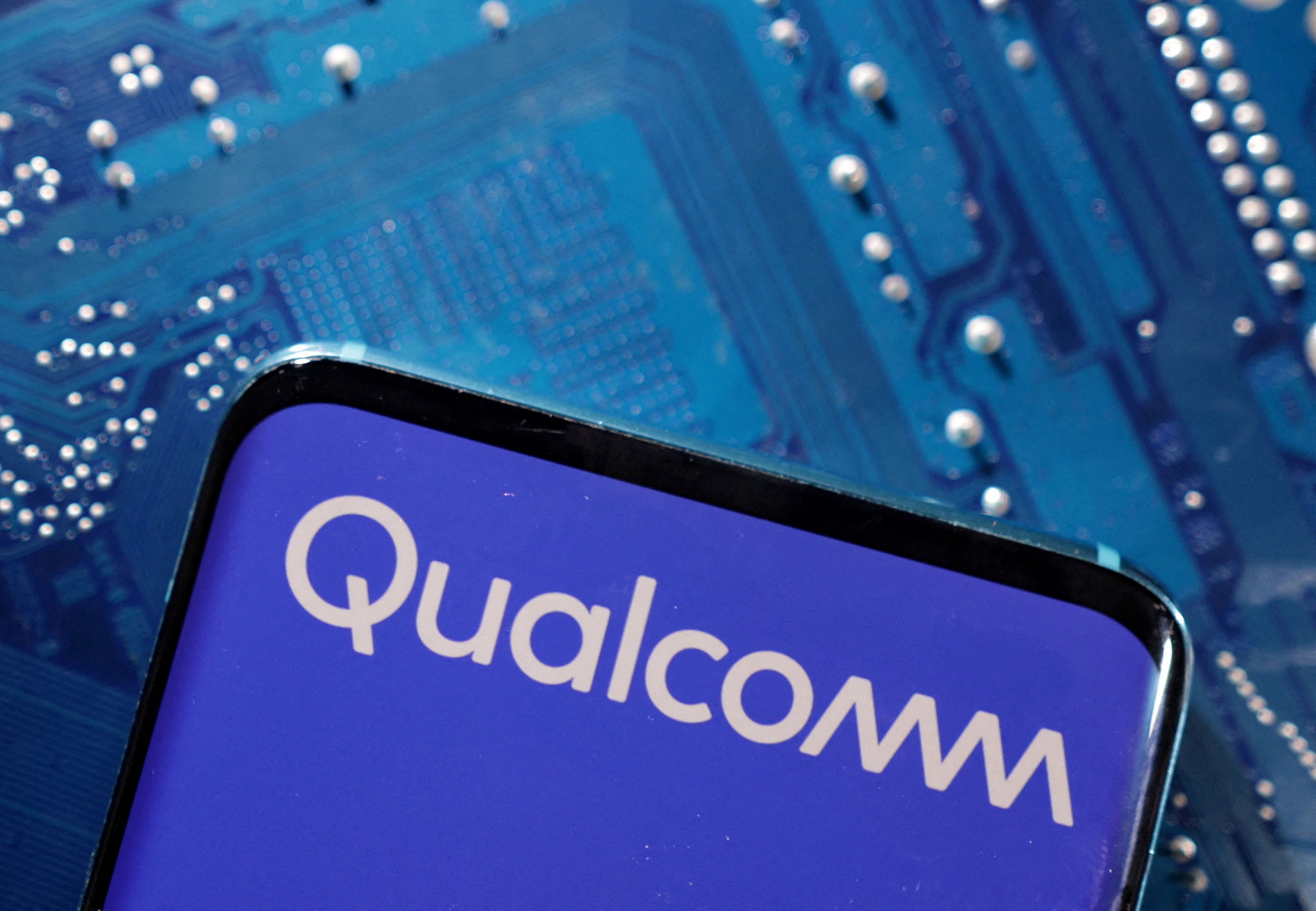 <div class="paragraphs"><p>A smartphone with a displayed Qualcomm logo is placed on a computer motherboard in this illustration.</p></div>