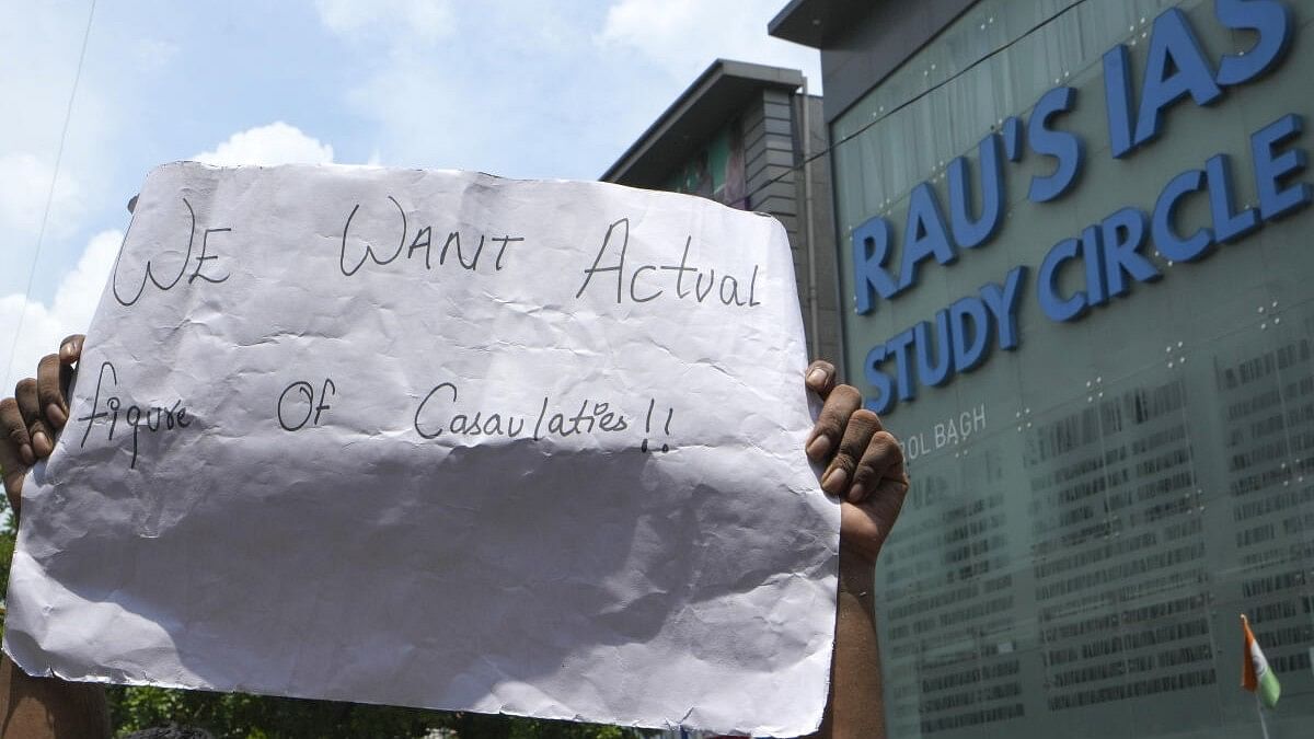 <div class="paragraphs"><p>A student holds a poster during a protest outside Rau’s IAS Study Circle where three students died after the basement of the building was flooded following heavy rain at Old Rajinder Nagar, in New Delhi</p></div>