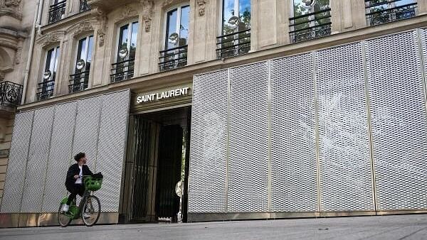 <div class="paragraphs"><p>A man rides his bicycle past protected windows of Saint Laurent's store on the Champs-Elysees avenue during the second round of the early French parliamentary election, in Paris, France, July 7, 2024.</p></div>