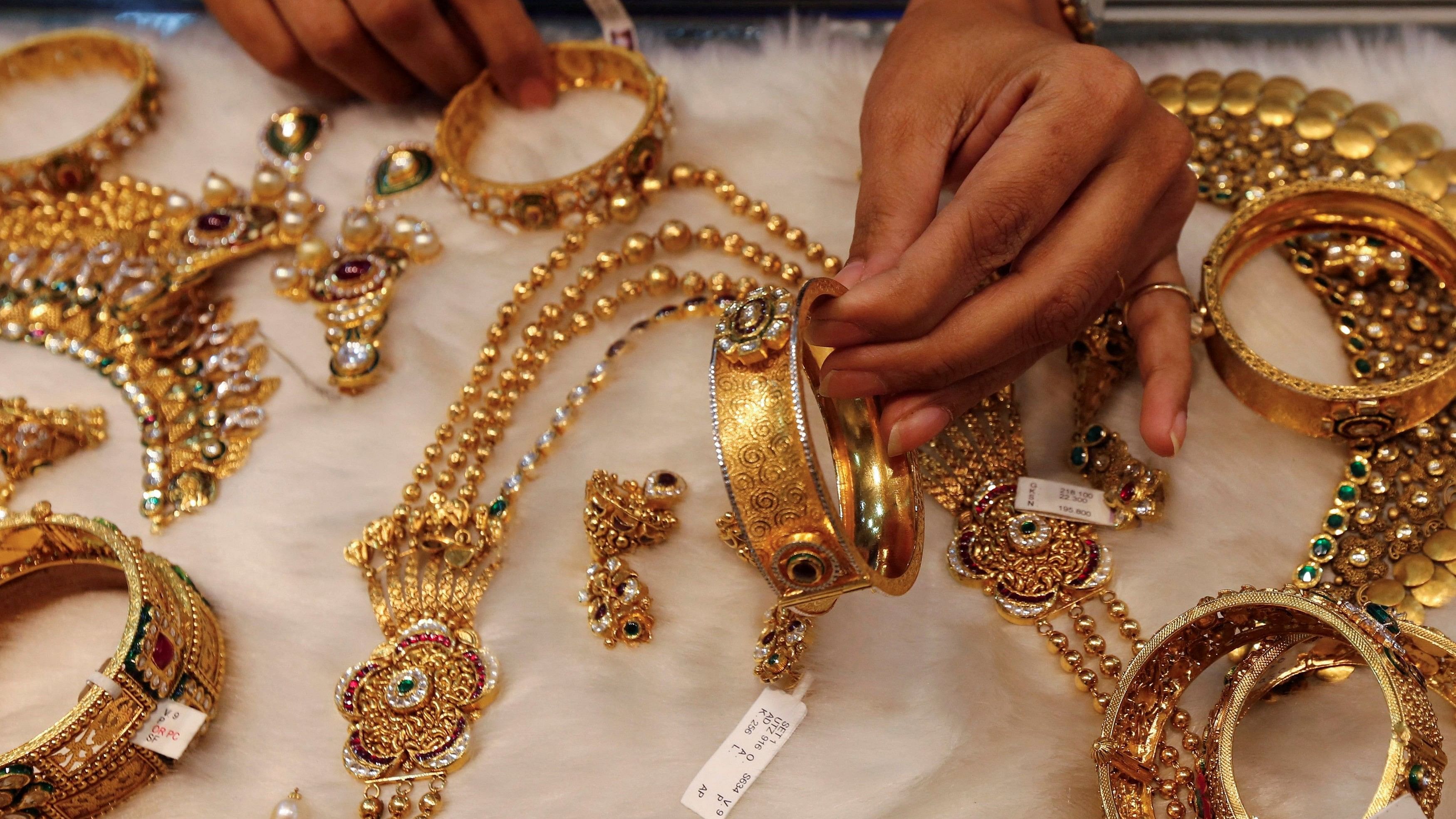 <div class="paragraphs"><p> A woman looks at a gold bangle inside a jewellery showroom at a market in Mumbai.&nbsp;</p></div>