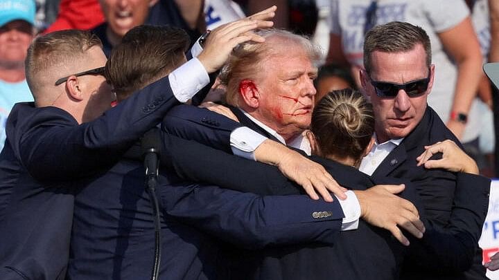 <div class="paragraphs"><p>Former US president Donald Trump protected by US Secret Service agents during the shooting in his election rally in Pennsylvania.</p></div>