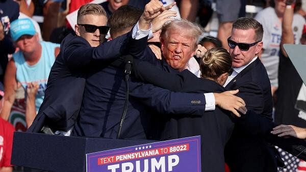 <div class="paragraphs"><p>Republican presidential candidate and former US President Donald Trump gestures with a bloodied face while he is assisted by US Secret Service personnel after he was shot in the right ear during a campaign rally at the Butler Farm Show in Butler, Pennsylvania, US, on July 13, 2024. </p></div>