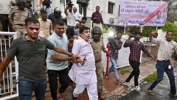 <div class="paragraphs"><p> Police personnel detain protestors after a clash broke out between Bajrang Dal &amp; BJP and Congress workers during a protest against Rahul Gandhi's remark on BJP that "You are not Hindus" in Lok Sabha, at the Congress office in Ahmedabad.</p></div>