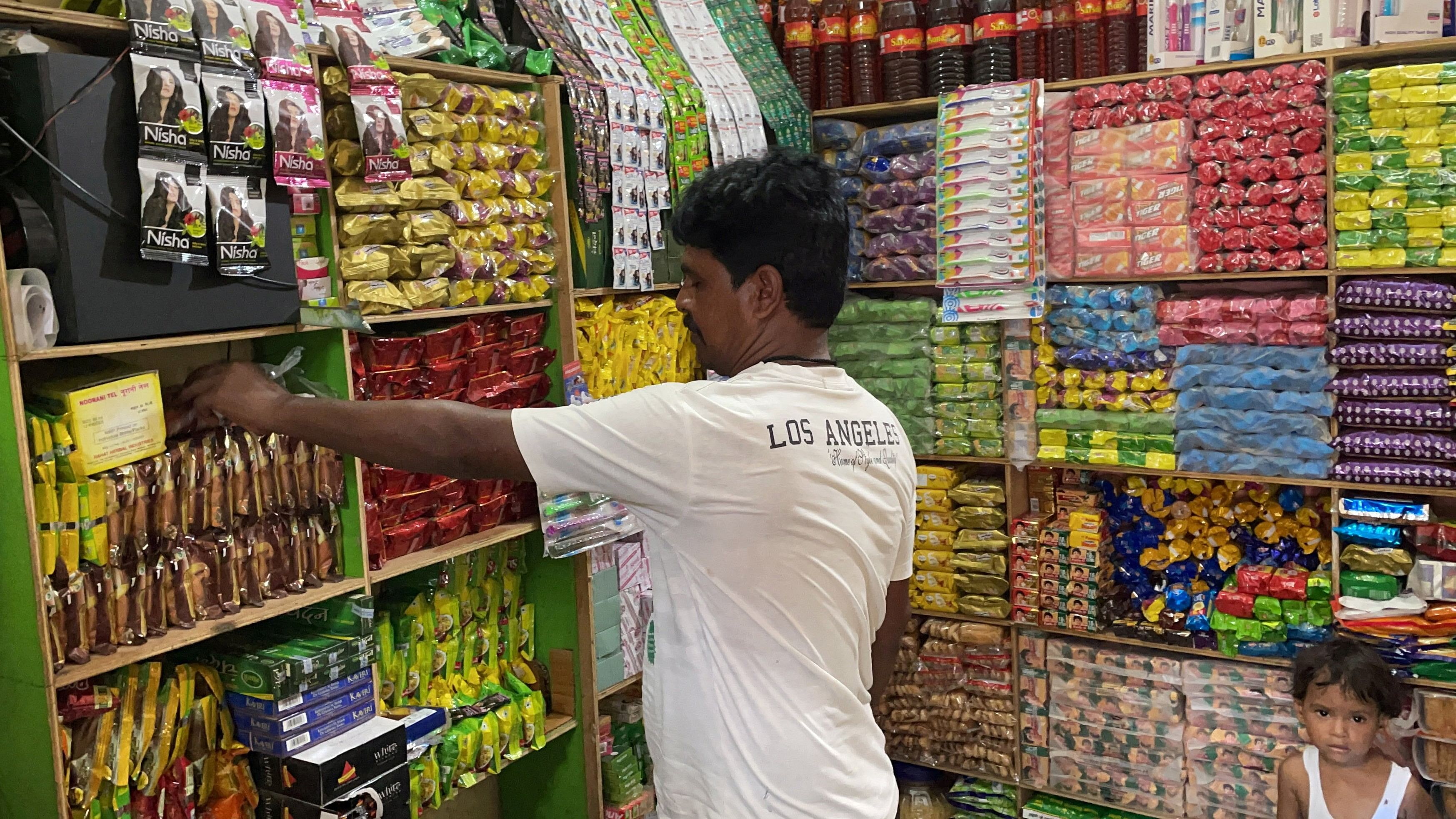 <div class="paragraphs"><p>Gosh Mohammed, 43, a retail shop owner, arranges snacks inside his shop in Dihwa village in the northern state of Uttar Pradesh</p></div>