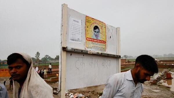 <div class="paragraphs"><p>People stand near a poster of preacher Surajpal, also known as 'Bhole Baba' stuck on a board, at the site where believers had gathered for a Hindu religious congregation following which a stampede occurred, in Hathras district of the northern state of Uttar Pradesh.&nbsp;</p></div>