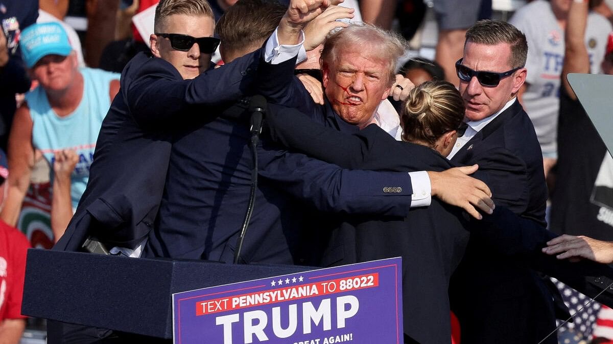 <div class="paragraphs"><p>Republican presidential candidate and former US President Donald Trump gestures with a bloodied face while he is assisted by US Secret Service personnel after he was shot in the right ear during a campaign rally at the Butler Farm Show in Butler, Pennsylvania.</p></div>