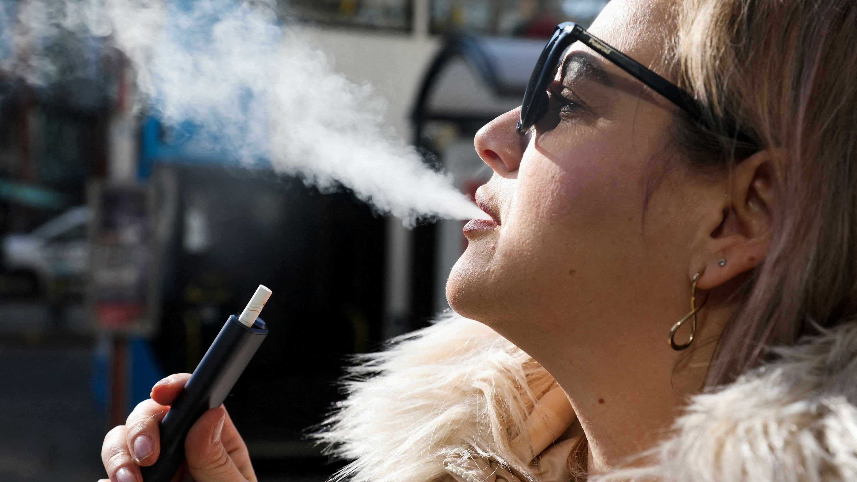 <div class="paragraphs"><p>A woman holds an e-cigarette</p></div>