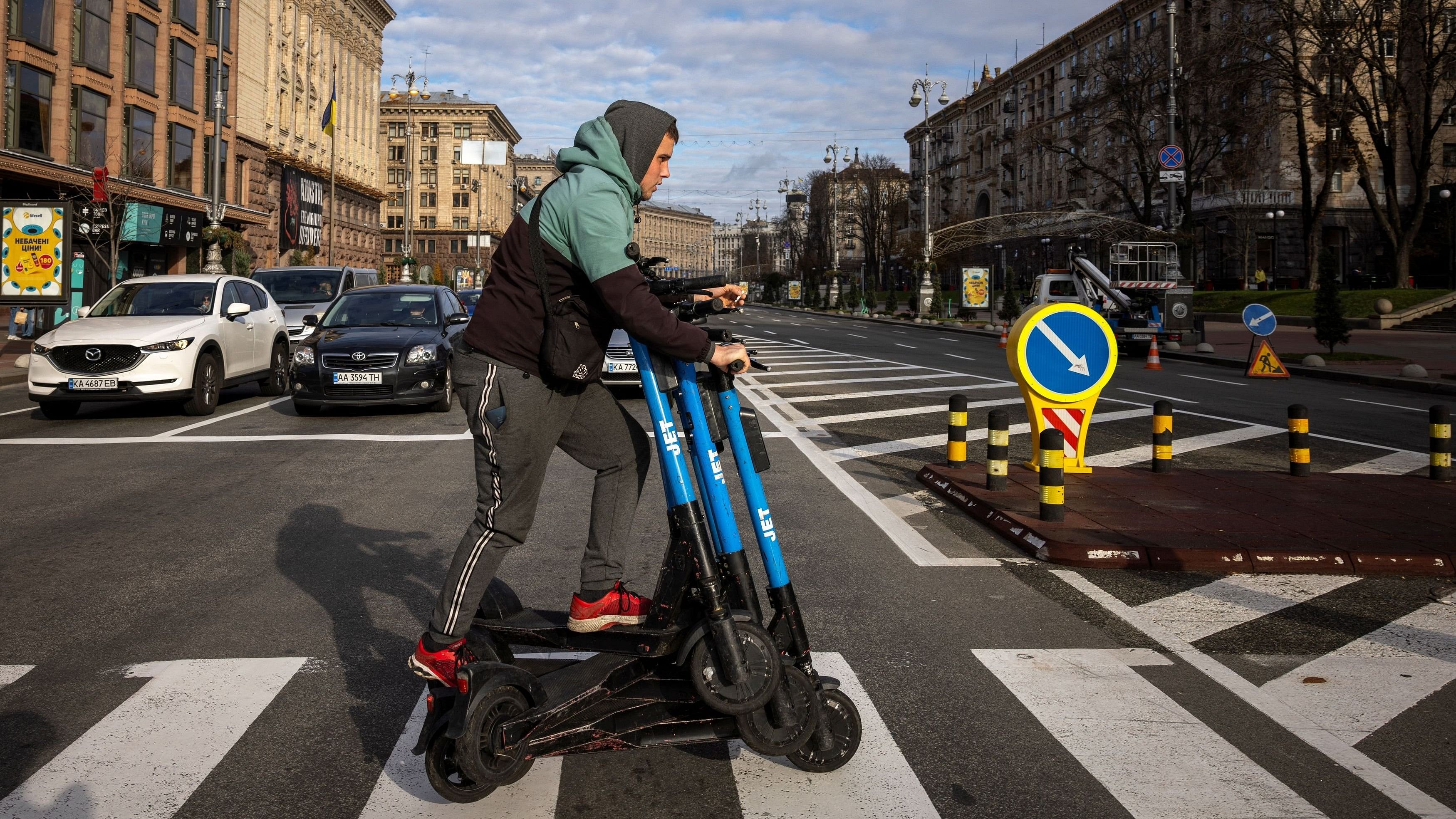 <div class="paragraphs"><p>A worker moves electric rental scooters across Khreschatyk Street in central Kyiv.</p></div>