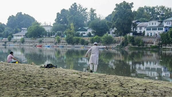 <div class="paragraphs"><p>People fish at River Jhelum, partially dried due to a long spell of dry weather and heatwave conditions, in Srinagar</p></div>