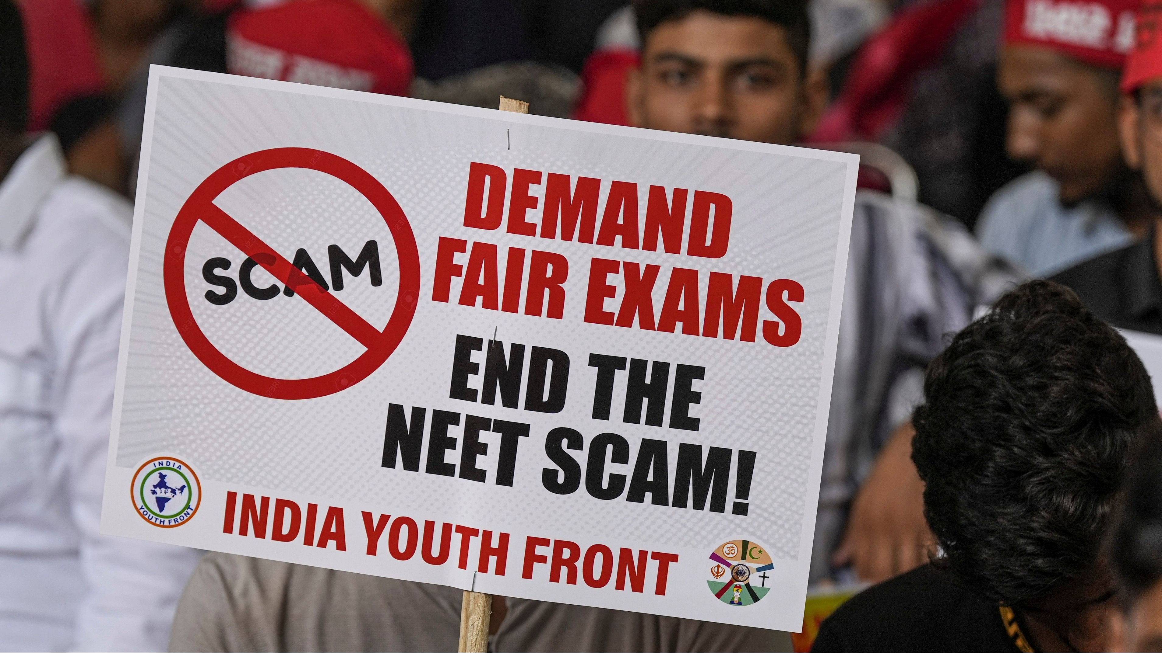 <div class="paragraphs"><p>An agitator holds a placard during a protest of the India Youth Front, an umbrella group representing I.N.D.I.A. bloc parties' youth wings, over the alleged irregularities in NEET 2024 results, at Jantar Mantar, in New Delhi, Monday, July 8, 2024.</p></div>