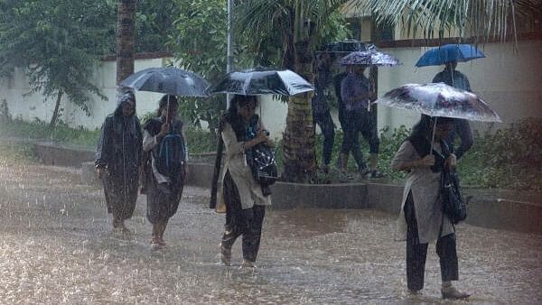 <div class="paragraphs"><p>Students walk amid heavy monsoon rains, in Bhubaneswar, Saturday, July 15, 2023</p></div>