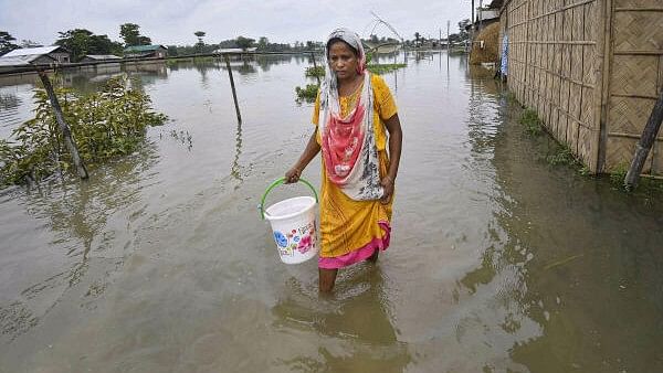 <div class="paragraphs"><p>A woman walks through a flood-affected area, in Nagaon district of Assam.</p></div>