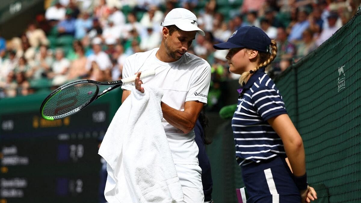 <div class="paragraphs"><p>Colombia's Daniel Elahi Galan wipes his hands on a towel as a ballkid looks on during his fourth round match against Italy's Jannik Sinner.</p></div>