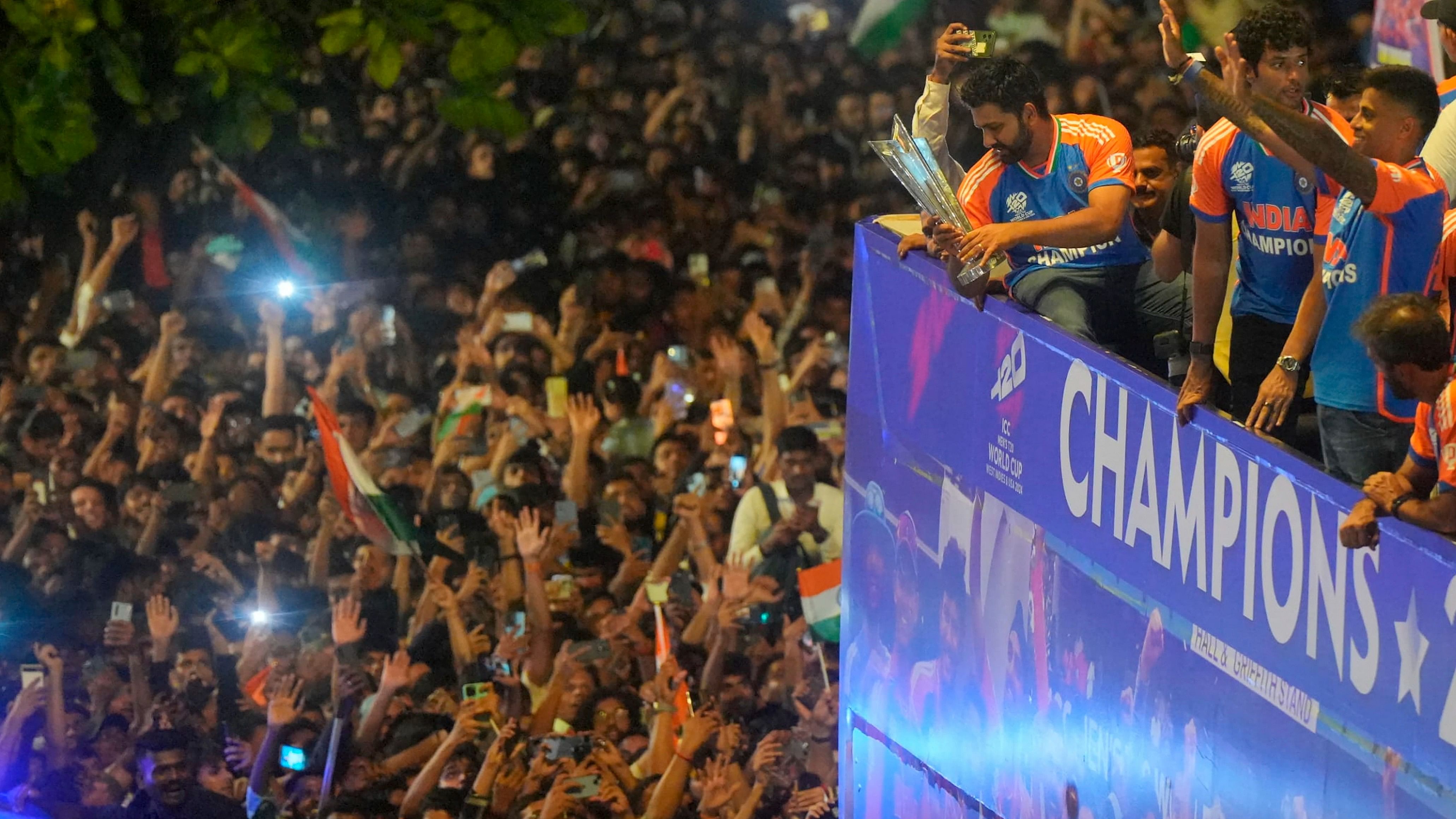 <div class="paragraphs"><p>T20 World Cup-winning Indian cricket team captain Rohit Sharma holding the championship trophy acknowledges fans during their open bus victory parade, in Mumbai, Thursday.</p></div>