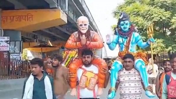 <div class="paragraphs"><p>Screengrab from a video showing kanwariya Rupendra Tomar carrying a statue of Prime Minister Narendra Modi on his shoulders.</p></div>