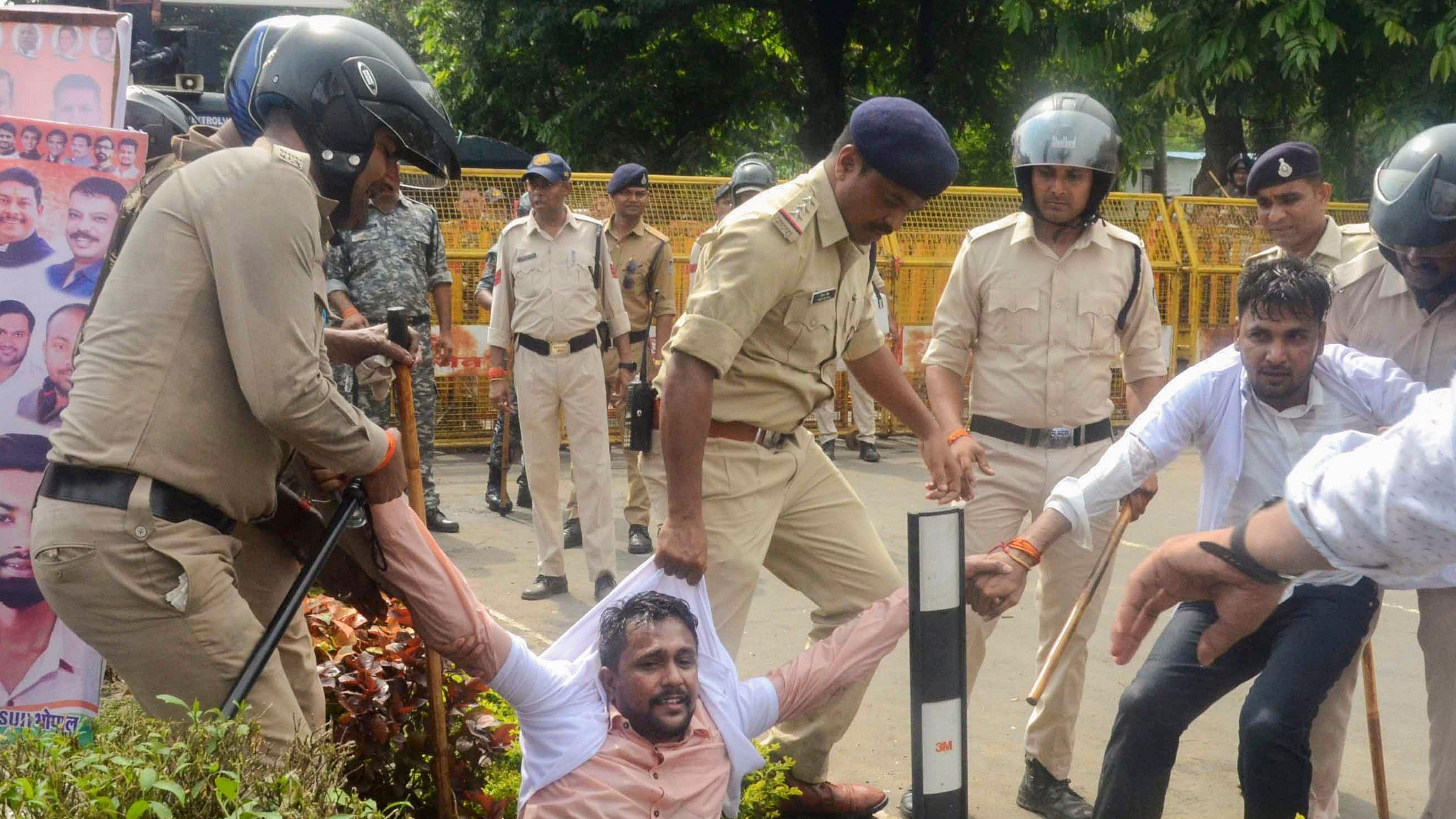 <div class="paragraphs"><p>Police personnel detain a National Students' Union of India (NSUI) activist during a demonstration against the alleged irregularities in NEET-UG exam 2024 and nursing college scam, in Bhopal.</p></div>