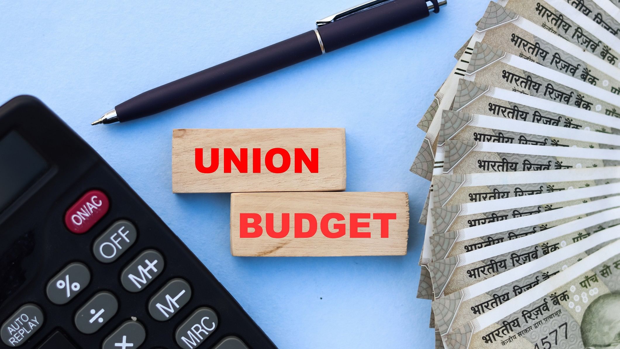 <div class="paragraphs"><p>Representative image showing a tile with the words 'Union Budget' flanked by a calculator to the left and Rs 500 notes to the right</p></div>