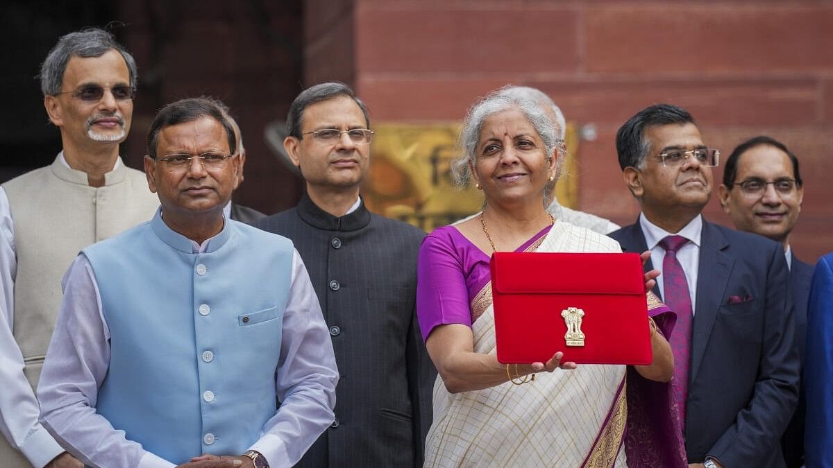 <div class="paragraphs"><p>Union Finance Minister Nirmala Sitharaman displays a red pouch carrying the Budget documents outside the Finance Ministry in North Block before leaving for the Parliament where she will table the Union Budget 2024-25, in New Delhi, Tuesday, July 23, 2024. </p></div>