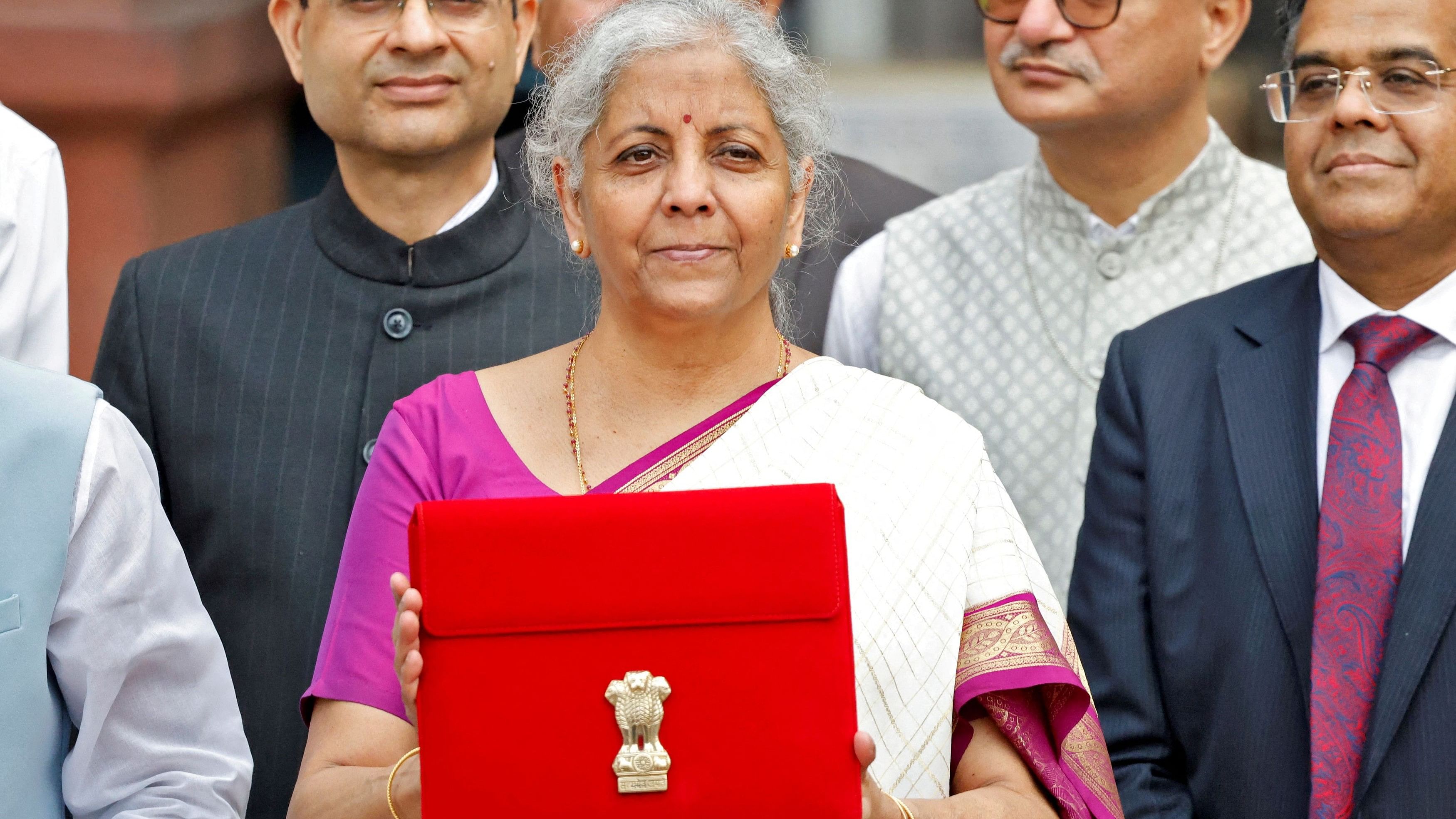 <div class="paragraphs"><p>Finance Minister Nirmala Sitharaman holds up a folder with the Government of India's logo, in New Delhi, on Tuesday</p></div>