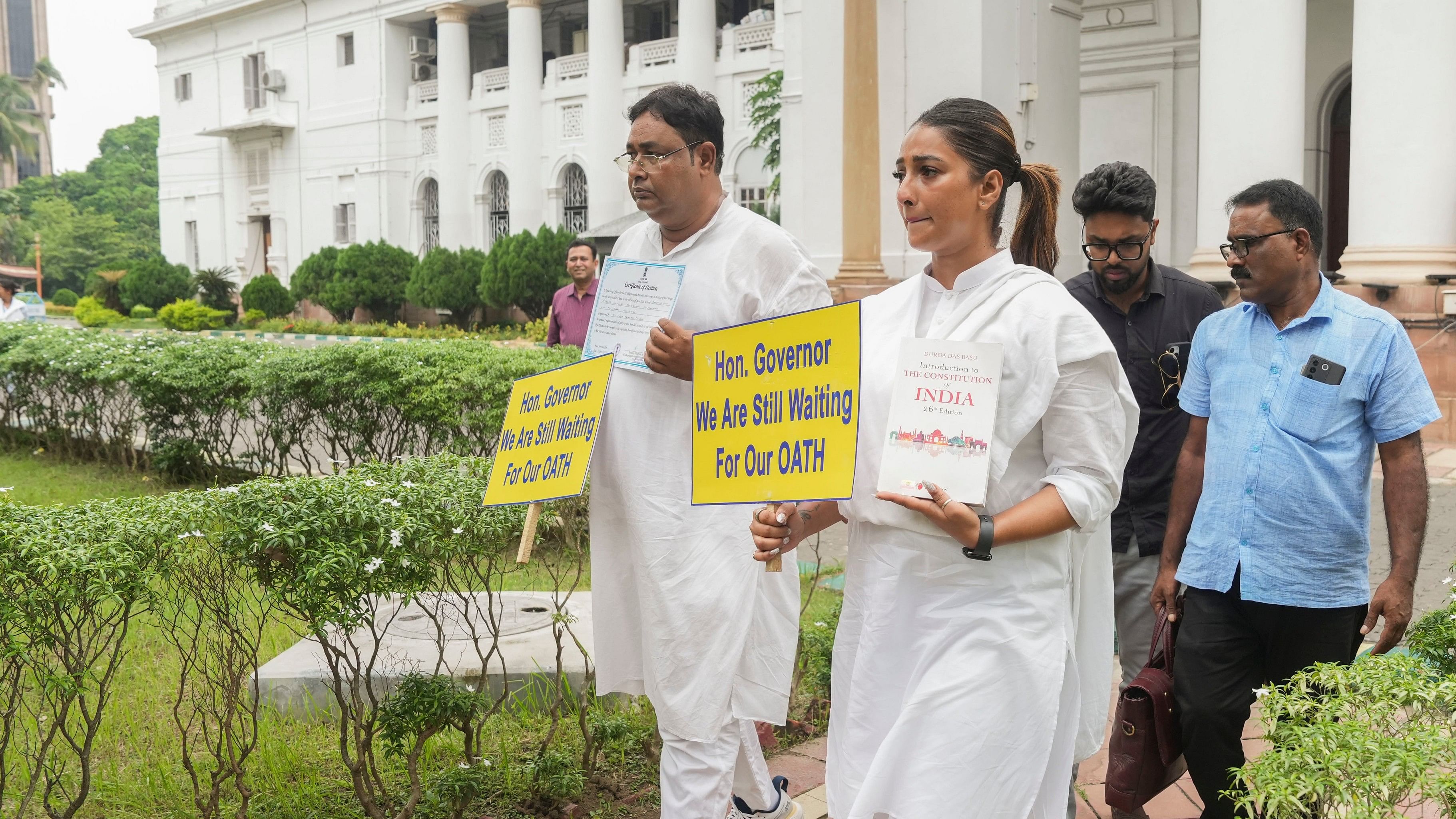 <div class="paragraphs"><p>Kolkata: Newly elected TMC MLAs Rayat Hossain Sarkar and Sayantika Banerjee walk for a sit-in protest for their swearing-in ceremony, in Kolkata</p></div>