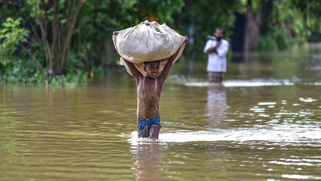 <div class="paragraphs"><p>A boy wades through a flooded area, following heavy rainfall, in Nagaon district in Assam</p></div>