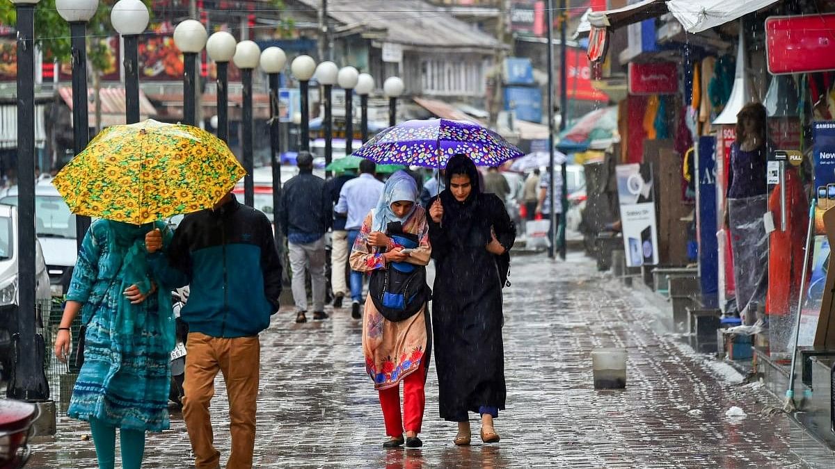 <div class="paragraphs"><p>Representative image showing pedestrians walking with umbrellas during heavy rains in Srinagar.</p></div>