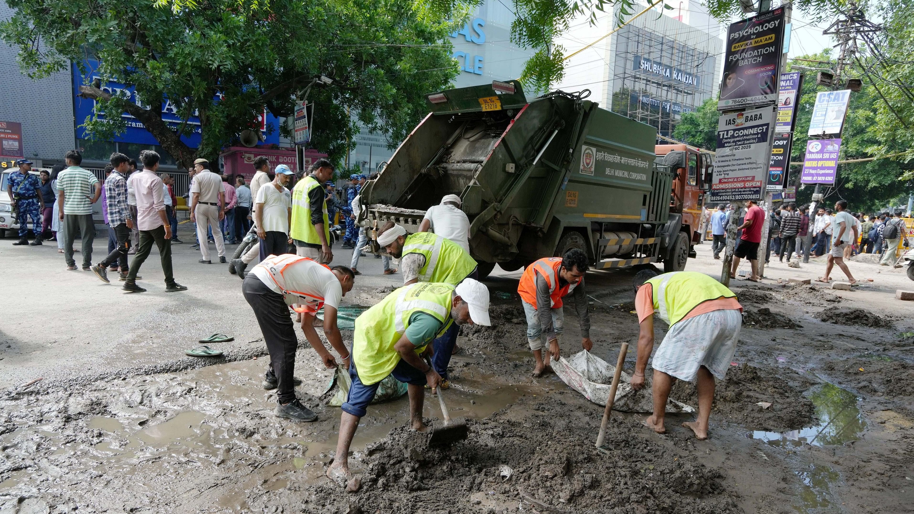 <div-Klasse="Absätze">
<p>Municipal workers repair a rain-damaged road near a UPSC exam preparation centre in New Delhi. The centre’s basement was flooded, leading to the death of three civil service aspirants.</p>
</div>
<p>“/></p>
<div class=