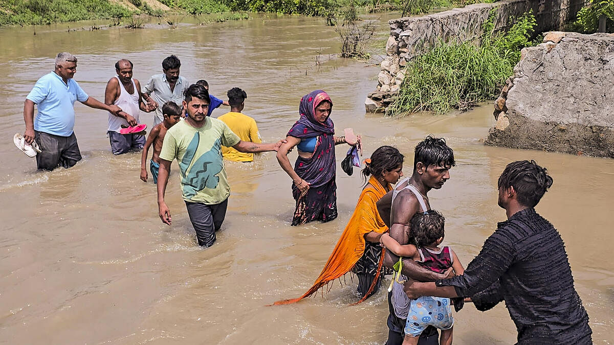 <div class="paragraphs"><p>People wade through floodwater after a breach in one of the sub-branches of Munak Canal, in New Delhi, Thursday, July 11, 2024.</p></div>