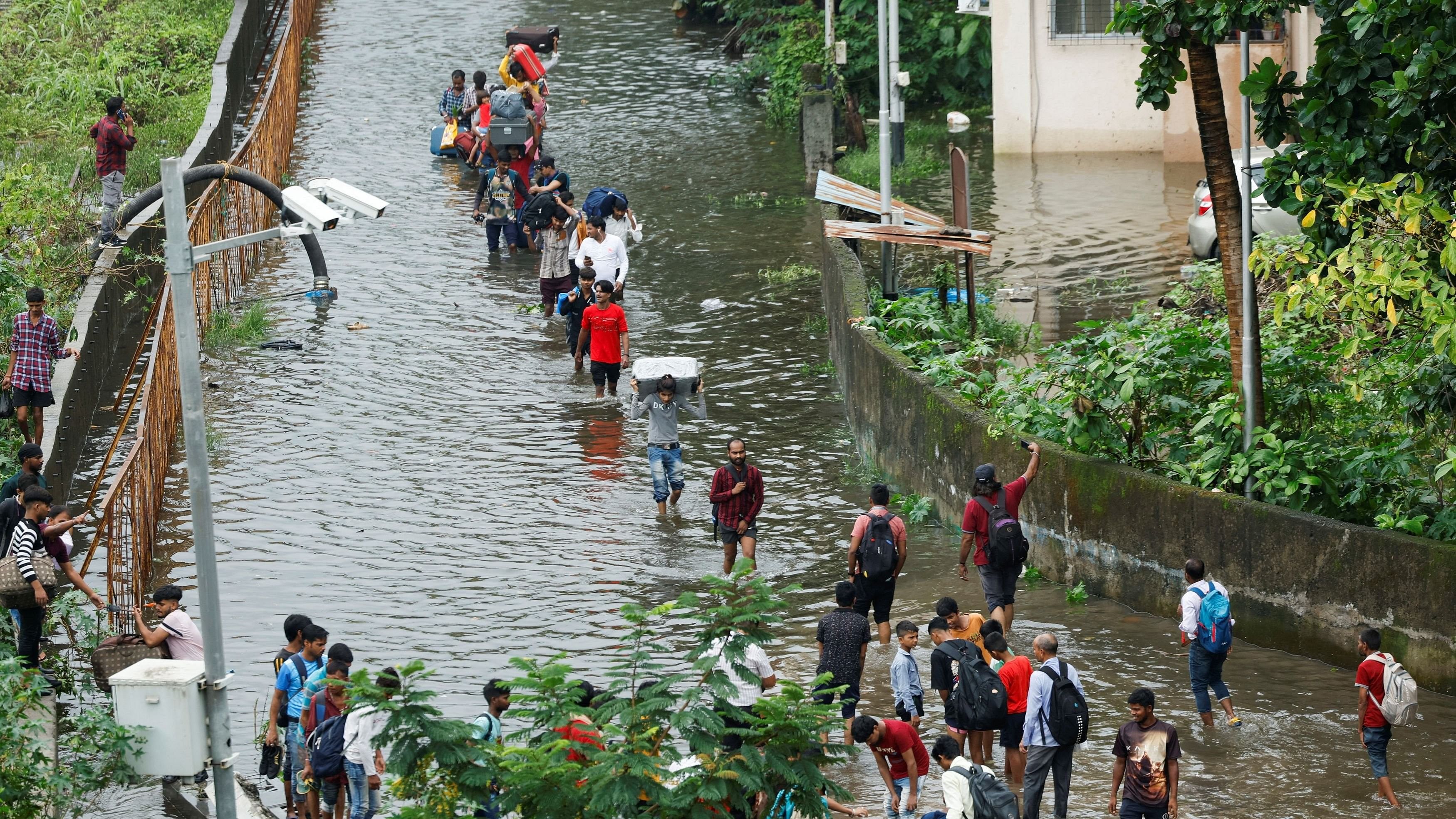 <div class="paragraphs"><p>People walk on a waterlogged street after heavy rains in Mumbai, July 8, 2024. </p></div>