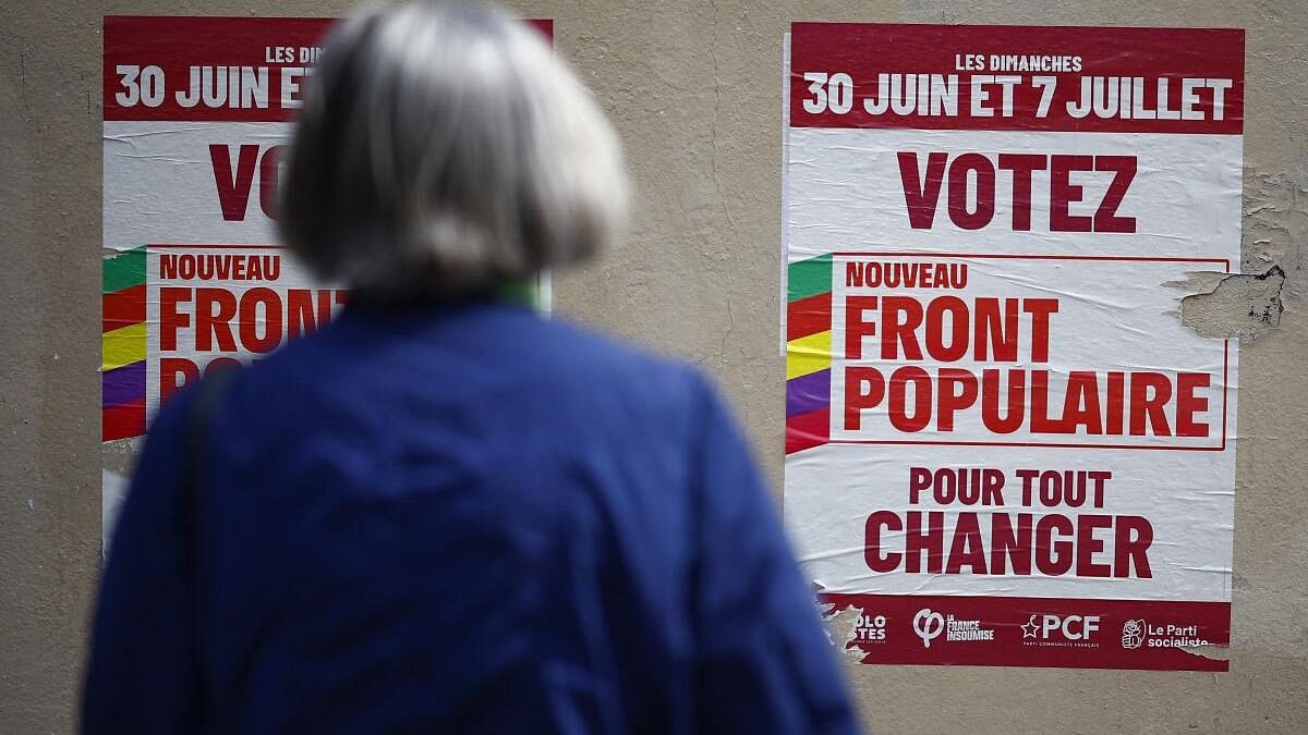 <div class="paragraphs"><p>A woman looks at campaign posters of the French left-wing alliance, named the Nouveau Front Populaire (New Popular Front - NFP) on the day of the second round of the early French parliamentary elections, in Paris.</p></div>