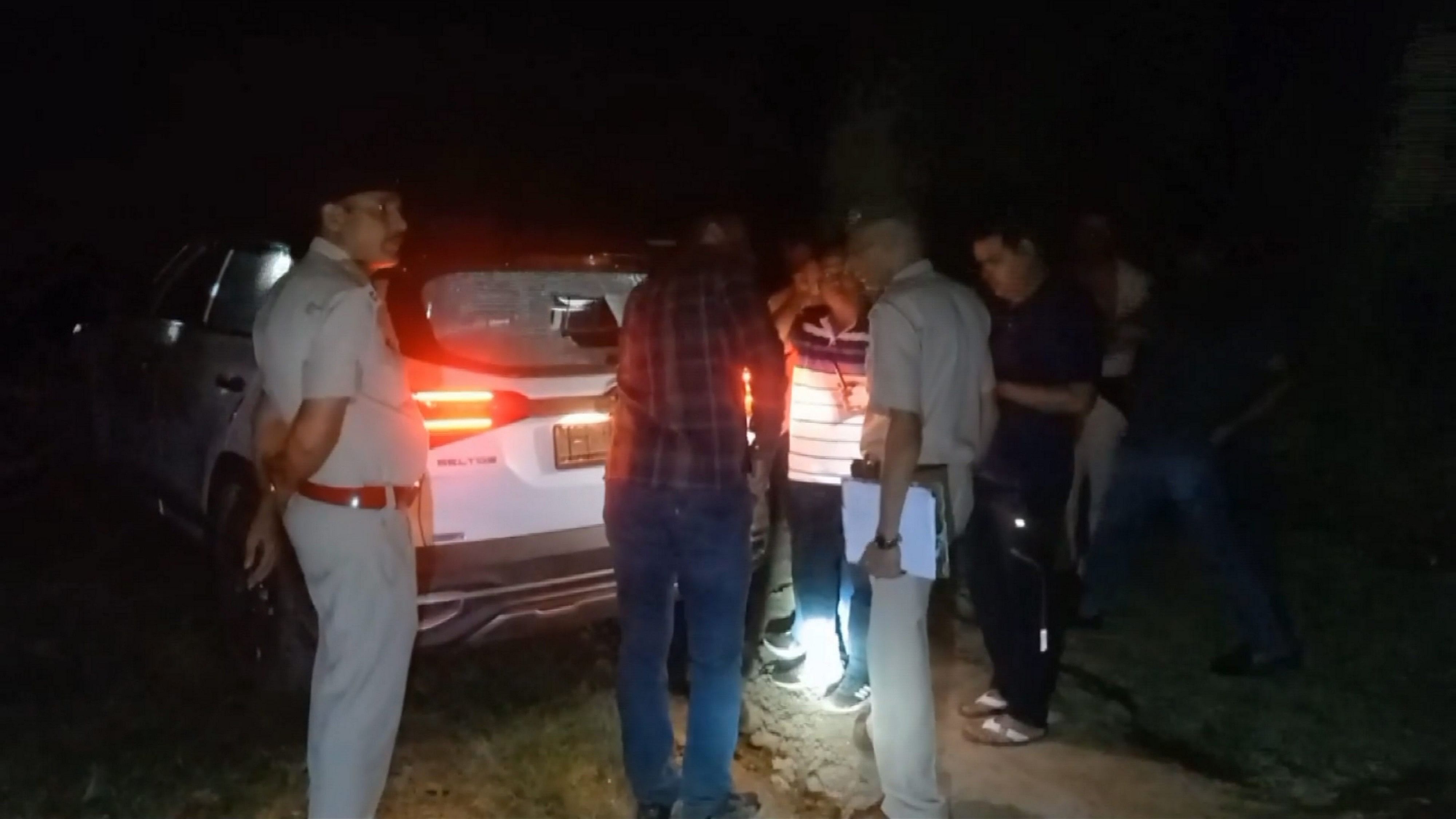 <div class="paragraphs"><p>Police personnel gather near a damaged vehicle after a shootout in which three members were gunned down by the Delhi Crime Branch and the Haryana STF, in Sonipat, Friday evening.</p></div>