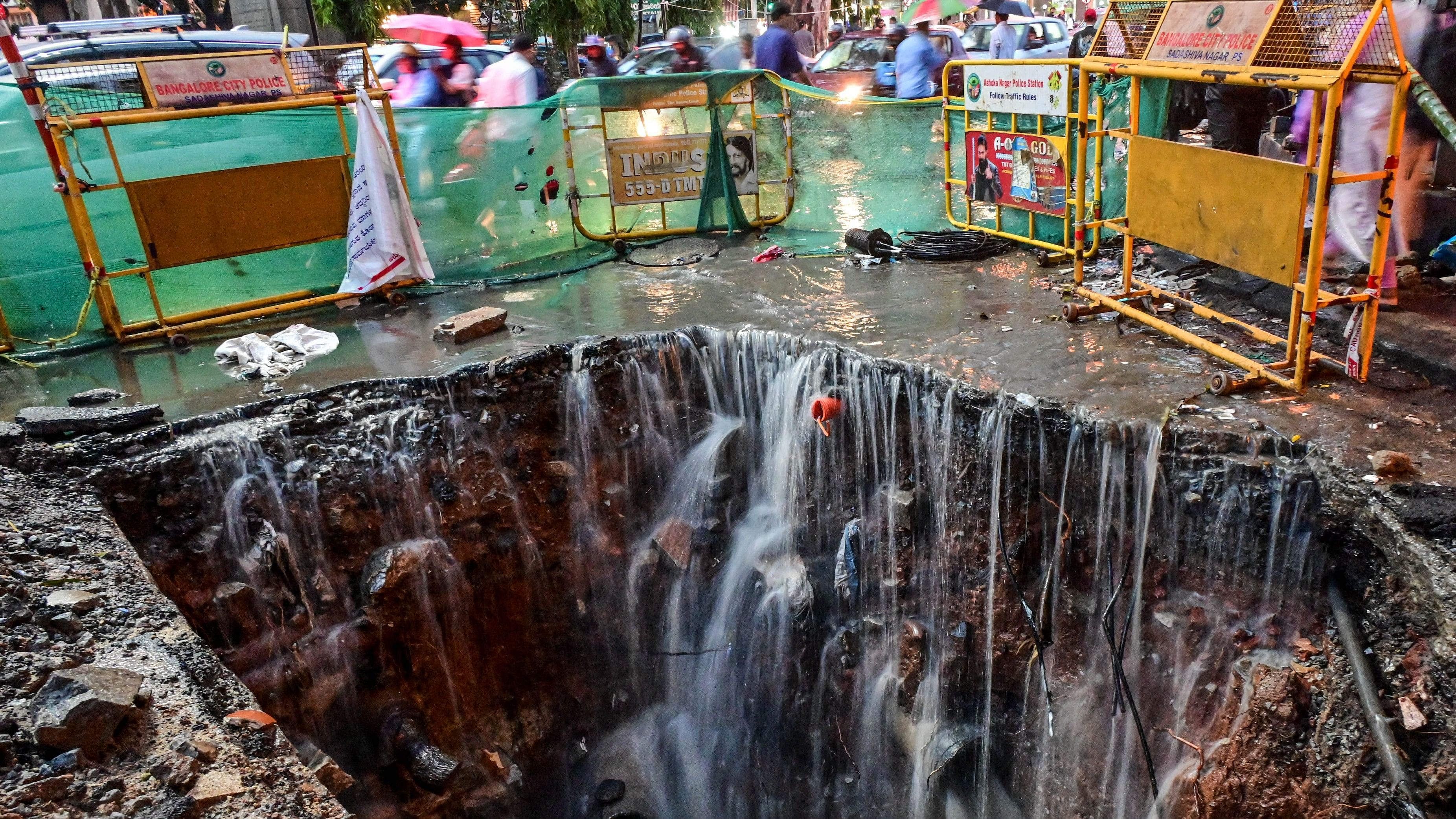 <div class="paragraphs"><p>Rainwater flows into a pit dug up on Brigade Road for underground drainage work. </p></div>