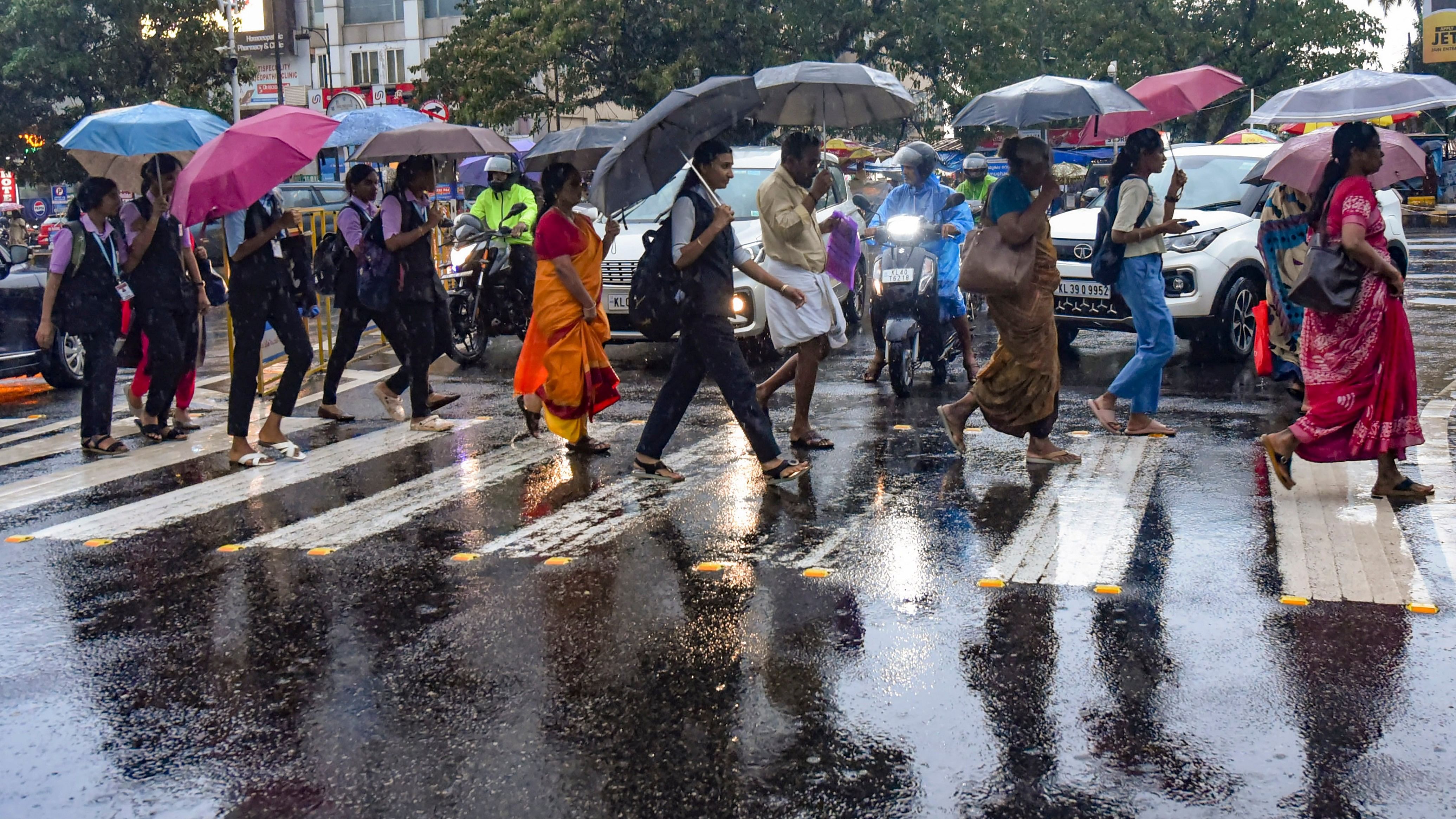 <div class="paragraphs"><p>Pedestrians hold umbrellas as they cross a street amid rains.</p></div>