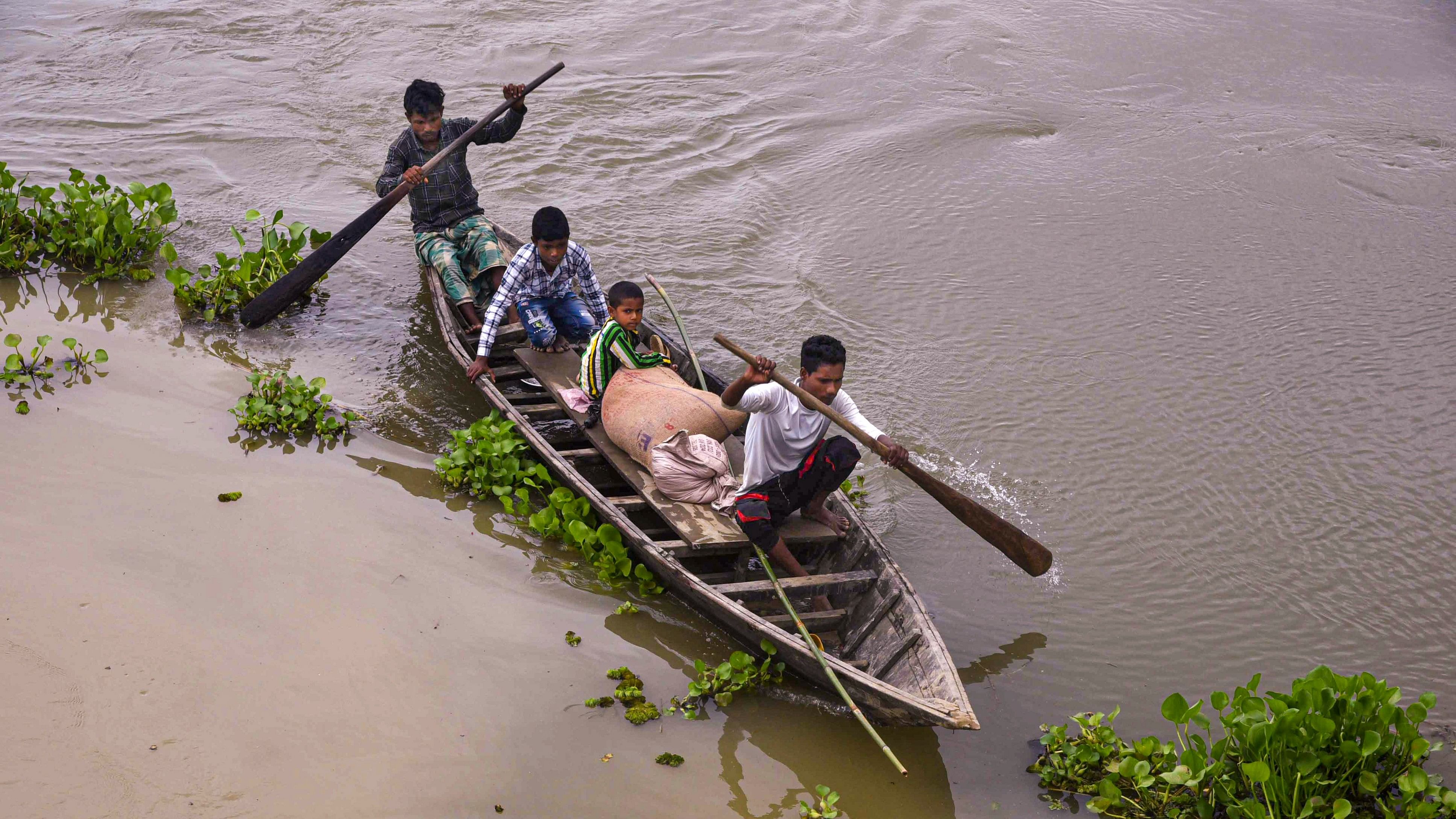 <div class="paragraphs"><p>Locals cross a flooded area on a boat, in Balimuk village of Morigaon district, Saturday, July 6, 2024.</p></div>