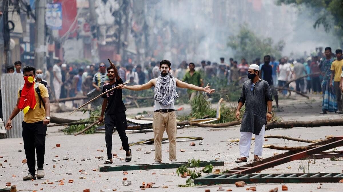 <div class="paragraphs"><p>A demonstrator gestures as protesters clash with Border Guard Bangladesh (BGB) and the police outside the state-owned Bangladesh Television as violence erupts across the country after anti-quota protests by students, in Dhaka, Bangladesh.</p></div>