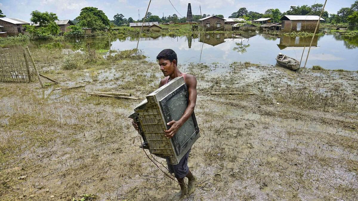 <div class="paragraphs"><p>A villager shifts his belongings from a flood affected area to a safer place, at Kaliabor in Nagaon district, Assam.</p></div>