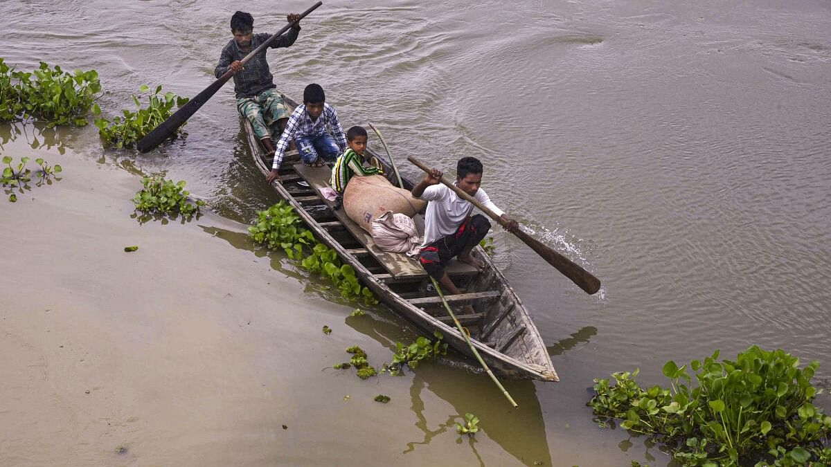 <div class="paragraphs"><p>Locals cross a flooded area on a boat, in Balimuk village of Morigaon district.</p></div>