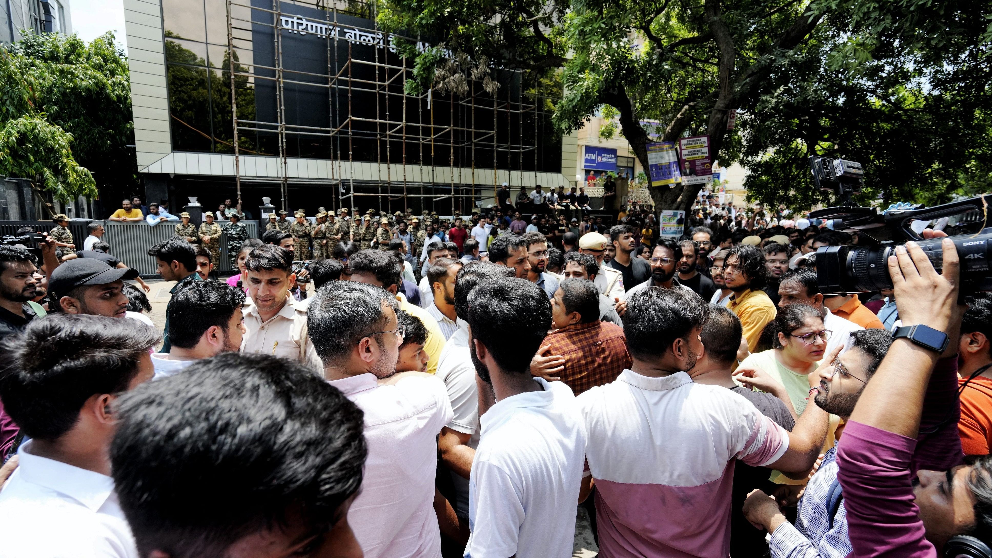 <div class="paragraphs"><p>Security personnel interact with students protesting over the death of three civil services aspirants after the basement of a coaching centre was flooded by rainwater.</p></div>