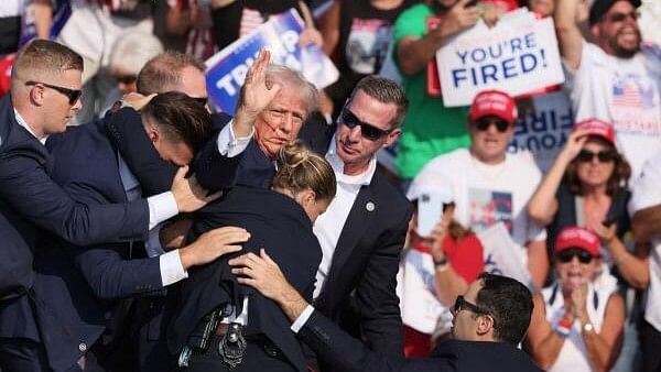 <div class="paragraphs"><p>Republican presidential candidate and former US President Donald Trump gestures with a bloodied face while he is assisted by U.S. Secret Service personnel after he was shot in the right ear during a campaign rally at the Butler Farm Show in Butler, Pennsylvania, US, July 13, 2024.</p></div>