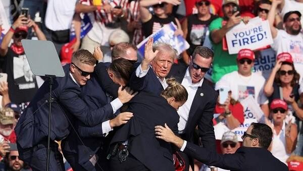 <div class="paragraphs"><p>Republican presidential candidate and former US President Donald Trump gestures with a bloodied face while he is assisted by US Secret Service personnel after he was shot in the right ear during a campaign rally at the Butler Farm Show in Butler, Pennsylvania, US, July 13, 2024.</p></div>