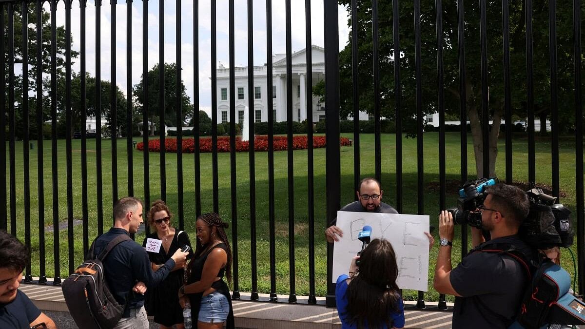 <div class="paragraphs"><p>A person holds a placard, as people gather outside the White House after U.S. President Joe Biden announced he is stopping his bid for reelection, in Washington</p></div>