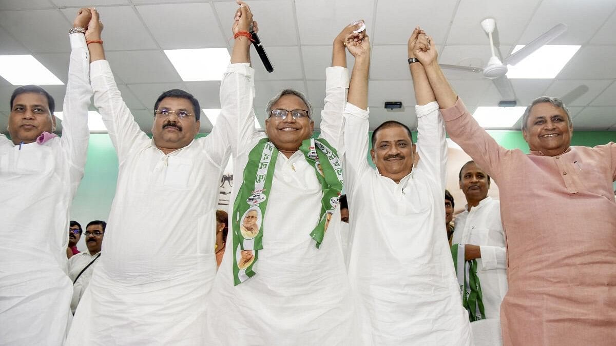 <div class="paragraphs"><p>JD(U) Working President Sanjay Kumar Jha and state President Umesh Kushwaha join hands with senior IAS Manish Verma (centre) as he joins the party, in Patna.</p></div>