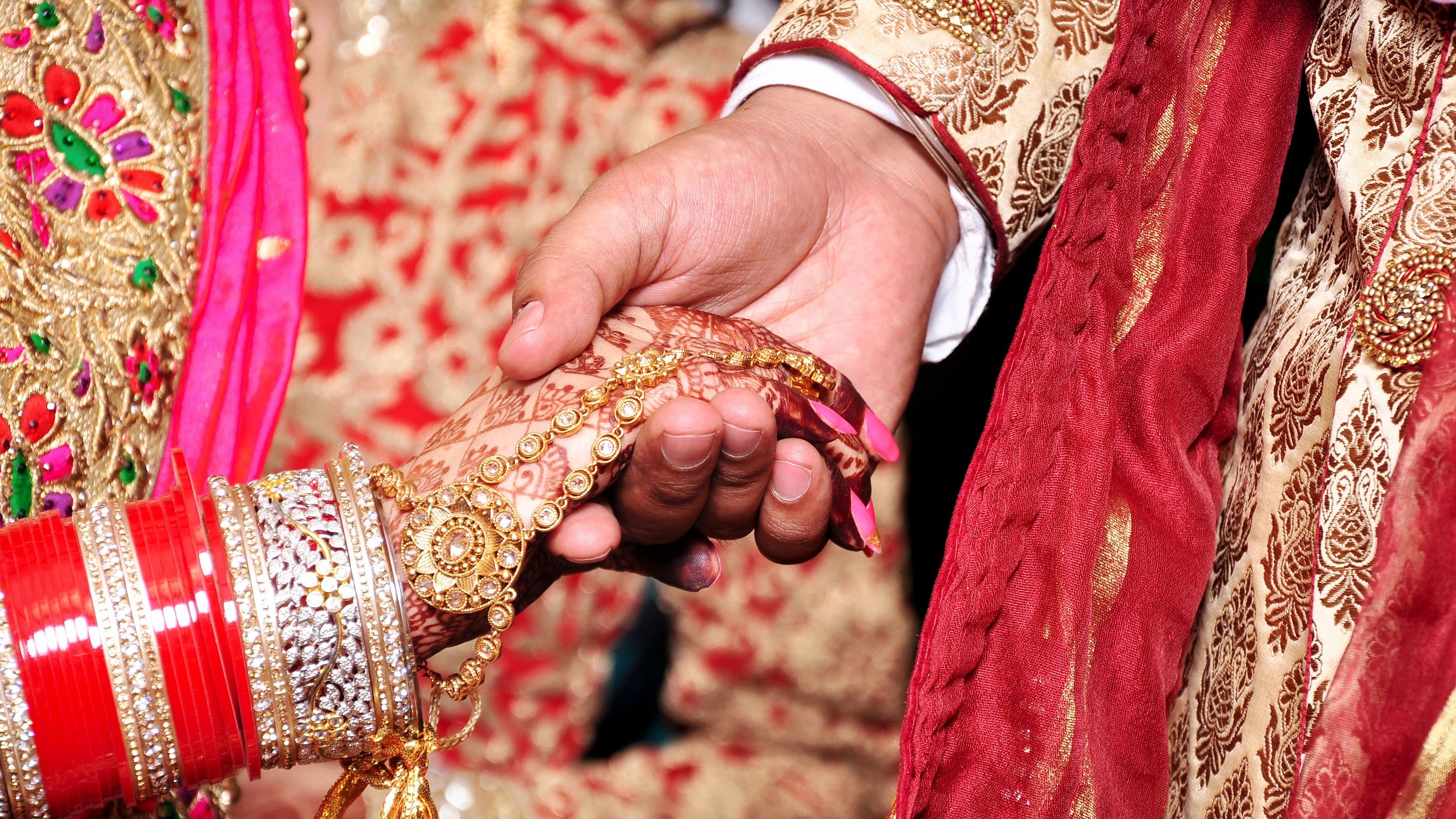 <div class="paragraphs"><p>Bride &amp; groom hand' together in Indian wedding</p></div>