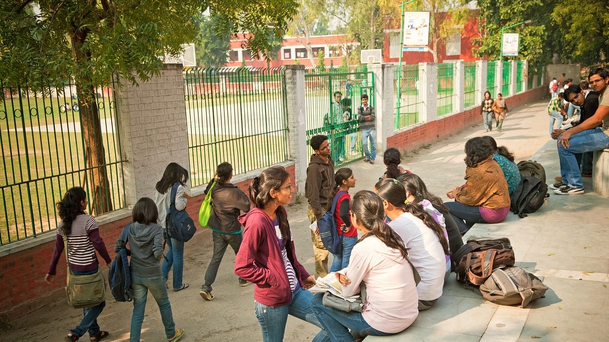 <div class="paragraphs"><p>Students sit outside the Delhi University's Hansraj College.</p></div>